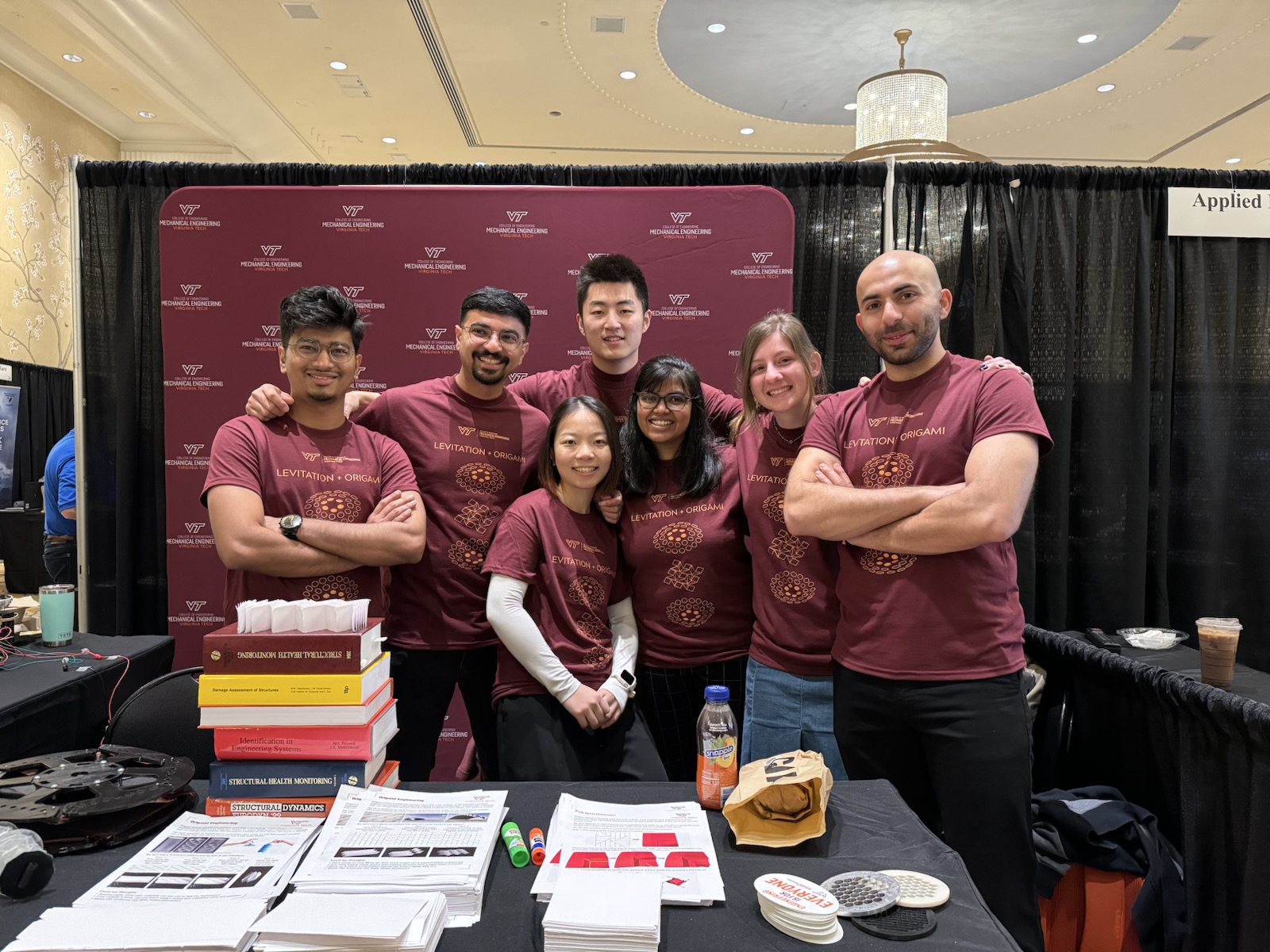Ziyang Zhou standing with members of the DARE Lab team at a conference exhibit