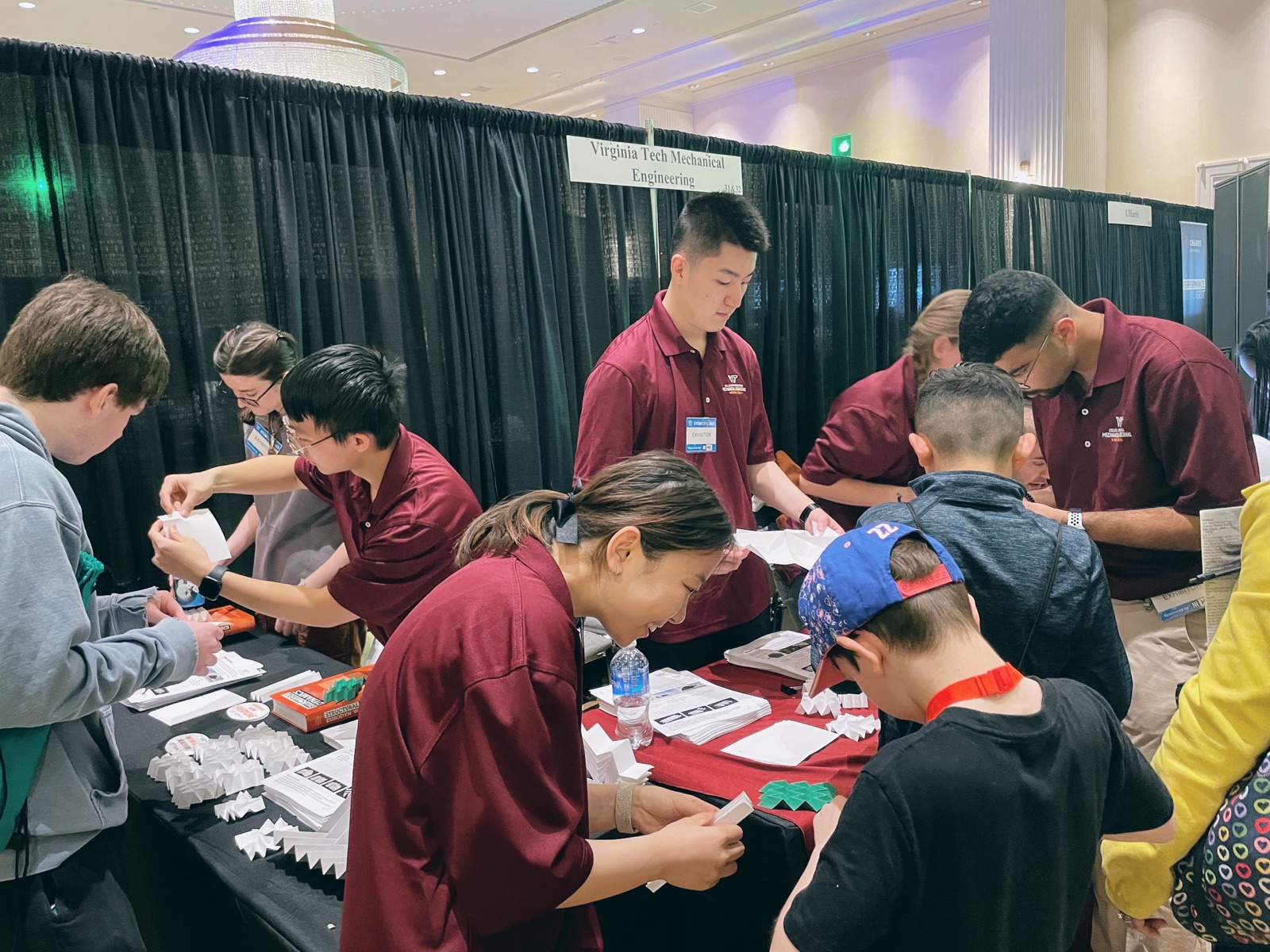 Ziyang Zhou and Virginia Tech colleagues sharing hands-on origami activities with visitors